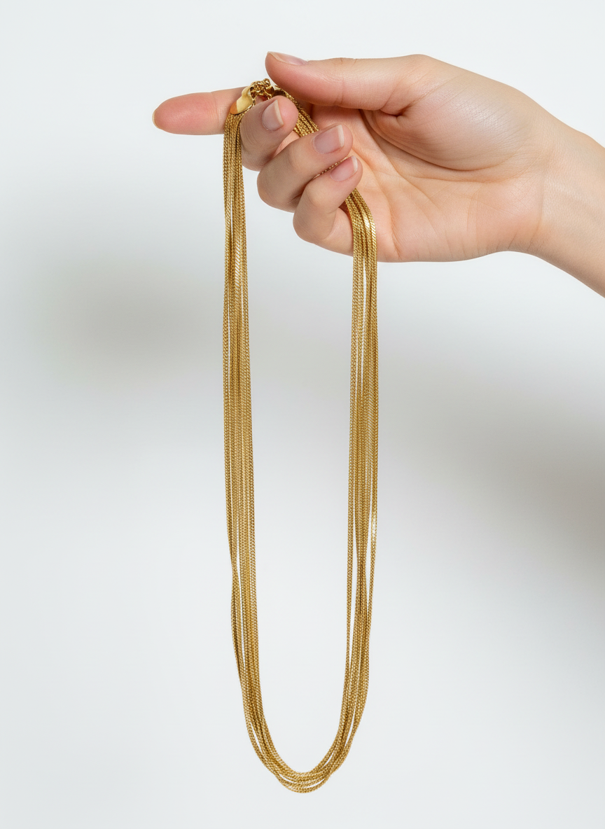 Mão segurando colar dourado