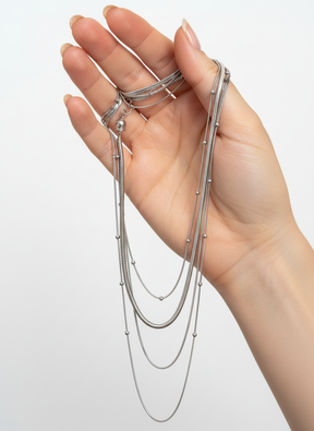 Mão segurando colar de correntes prateadas
