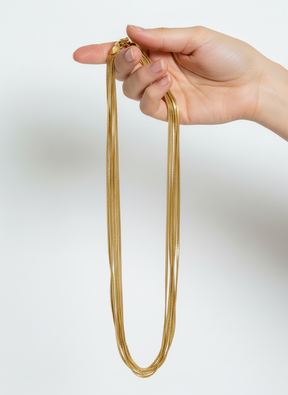 Mão segurando colar dourado