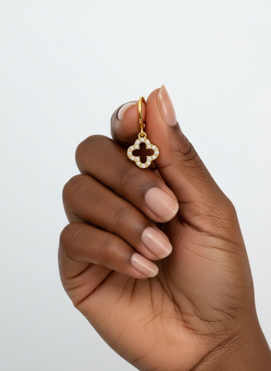 Mão segurando um brinco dourado