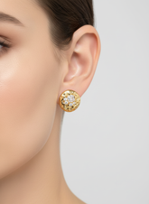 Pessoa usando brincos de ouro com cristais